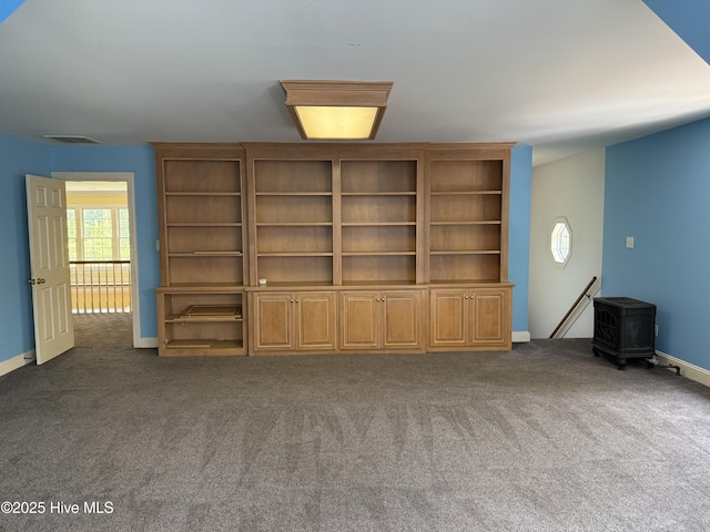 2602 Linden Ln NW, Wilson, NC 27896 - unfurnished living room featuring a wood stove, carpet, and baseboards