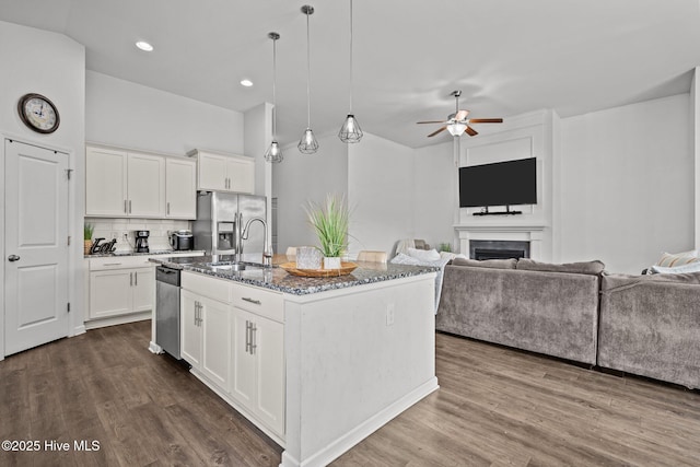 506 Esthwaite Dr SE, Leland, NC 28451 - kitchen with open floor plan, stainless steel appliances, stone counters, ceiling fan, and dark wood-type flooring