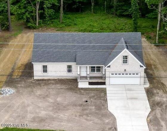 1064 Tulls Creek Rd, Moyock, NC 27958 - view of front of house featuring roof mounted solar panels, concrete driveway, and roof with shingles