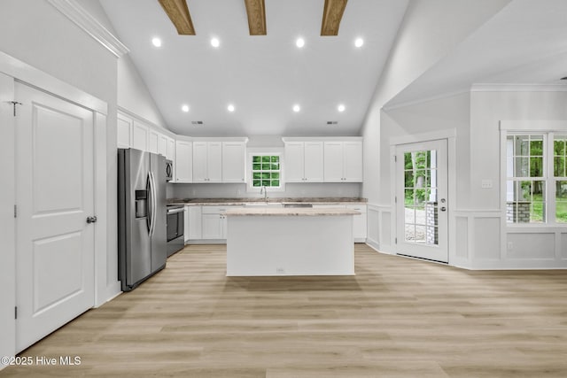 1064 Tulls Creek Rd, Moyock, NC 27958 - kitchen featuring stainless steel refrigerator with ice dispenser, a sink, vaulted ceiling, white cabinetry, and a kitchen island