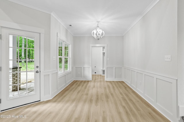 1064 Tulls Creek Rd, Moyock, NC 27958 - unfurnished dining area featuring a chandelier, crown molding, light wood-type flooring, a decorative wall, and wainscoting