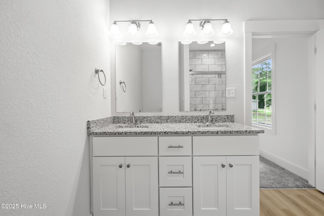 1064 Tulls Creek Rd, Moyock, NC 27958 - bathroom with wood finished floors, double vanity, a textured wall, and baseboards