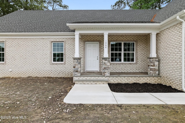 1064 Tulls Creek Rd, Moyock, NC 27958 - view of exterior entry featuring a porch, brick siding, and a shingled roof