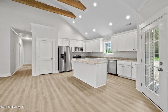 1064 Tulls Creek Rd, Moyock, NC 27958 - kitchen featuring appliances with stainless steel finishes, a kitchen island, high vaulted ceiling, recessed lighting, and white cabinetry