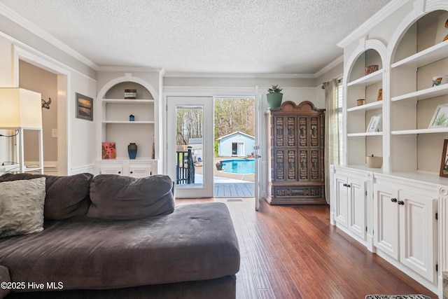 1714 Darian Dr, Elizabeth City, NC 27909 - living room featuring built in shelves, ornamental molding, a textured ceiling, and dark wood-type flooring