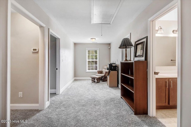  - sitting room with attic access, baseboards, and light colored carpet