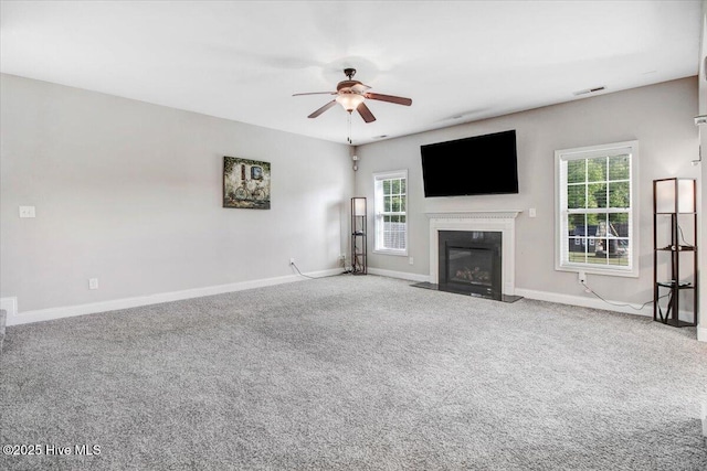  - unfurnished living room with baseboards, a ceiling fan, visible vents, and plenty of natural light
