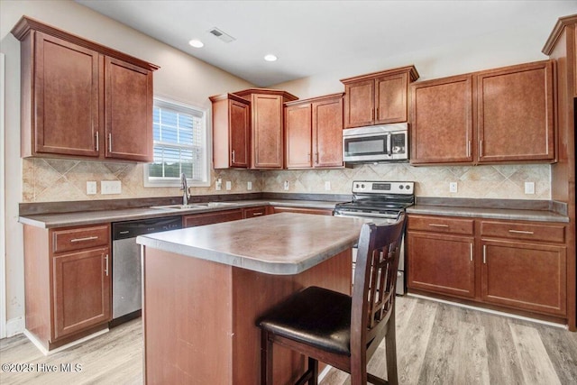  - kitchen featuring visible vents, a sink, light wood-style floors, and appliances with stainless steel finishes