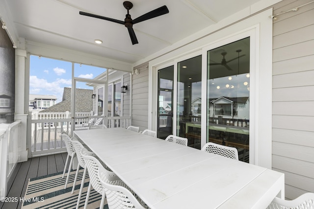 sunroom / solarium with a ceiling fan and outdoor dining space