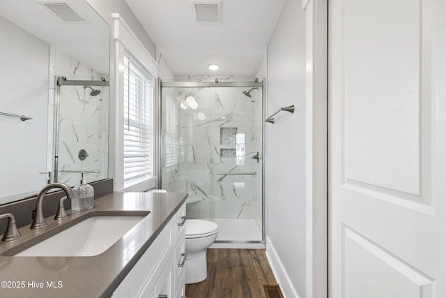 bathroom featuring toilet, visible vents, a marble finish shower, and vanity