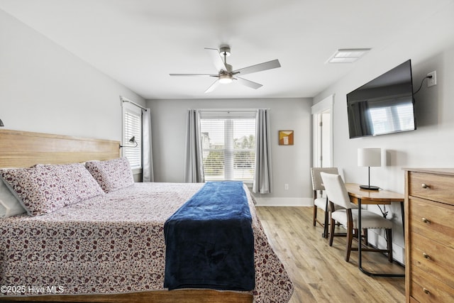 bedroom featuring baseboards, ceiling fan, light wood-style flooring, and visible vents