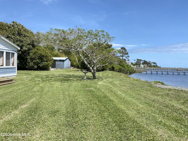 view of yard with a storage unit, an outdoor structure, and a water view