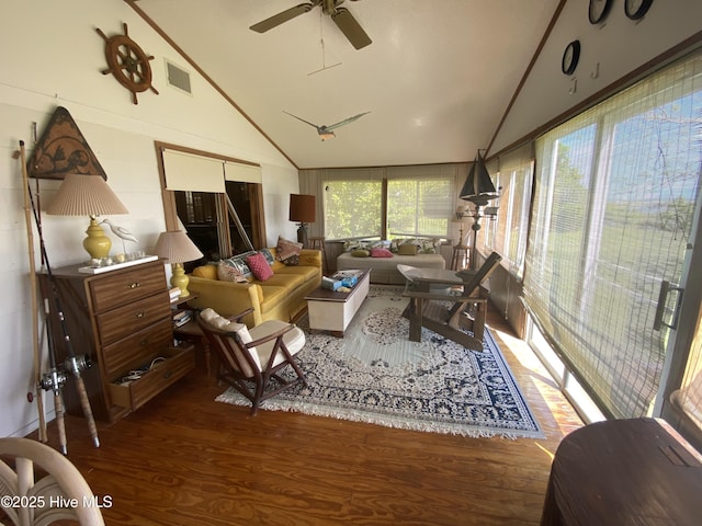 living area featuring wood finished floors, visible vents, ceiling fan, and high vaulted ceiling