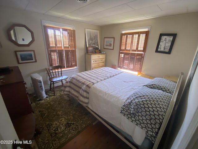 bedroom featuring visible vents and wood finished floors