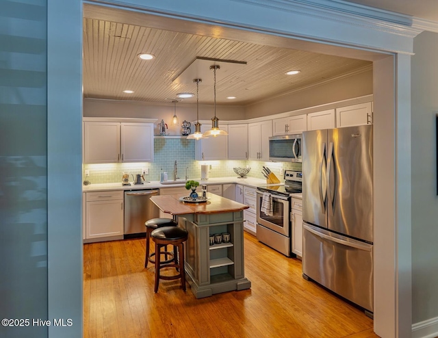 2111 Gibson Ave, Wilmington, NC 28403 - kitchen featuring a sink, white cabinets, backsplash, and stainless steel appliances