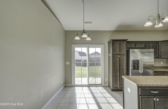kitchen featuring stainless steel fridge, light tile patterned floors, and an inviting chandelier
