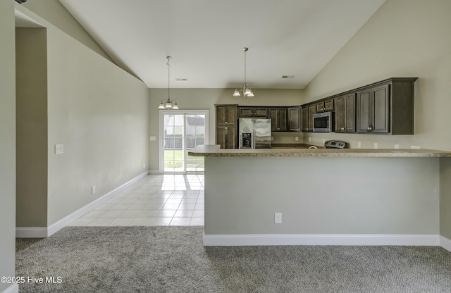 kitchen featuring stainless steel appliances, vaulted ceiling, light carpet, dark brown cabinetry, and a notable chandelier