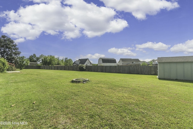 view of yard featuring a fenced backyard, an outdoor structure, and a shed