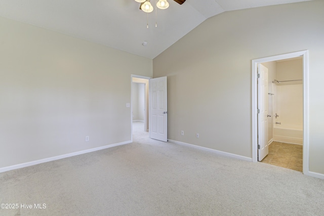 unfurnished bedroom with carpet flooring, baseboards, a ceiling fan, ensuite bath, and high vaulted ceiling