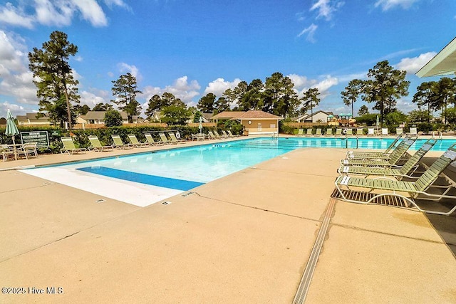 pool with a patio and fence
