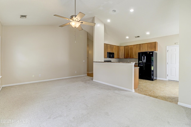 kitchen with a ceiling fan, baseboards, black appliances, brown cabinetry, and light colored carpet