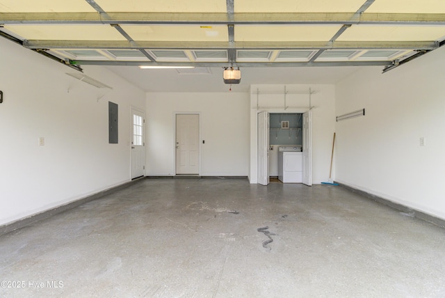 garage featuring electric panel, baseboards, a garage door opener, and washer and clothes dryer