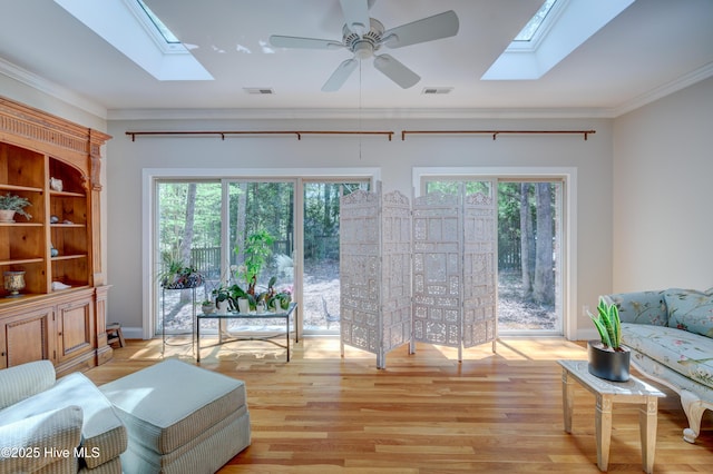 living area featuring visible vents, a ceiling fan, and a skylight
