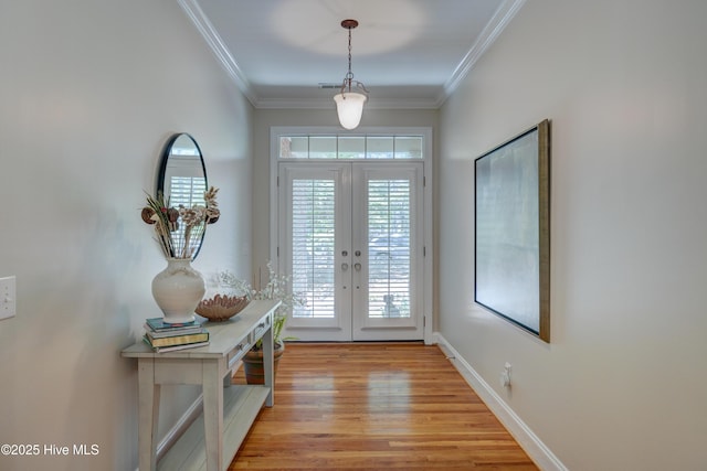 doorway with a healthy amount of sunlight, light wood-style floors, french doors, and crown molding