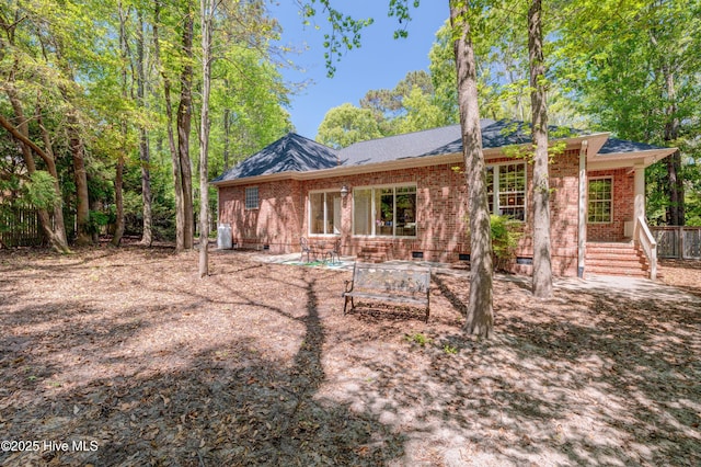 rear view of house with a patio area, crawl space, brick siding, and a shingled roof