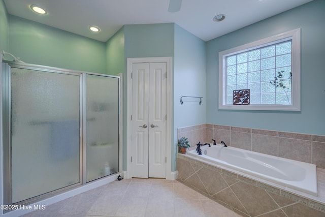 full bathroom featuring tile patterned flooring, a bath, a stall shower, and a closet