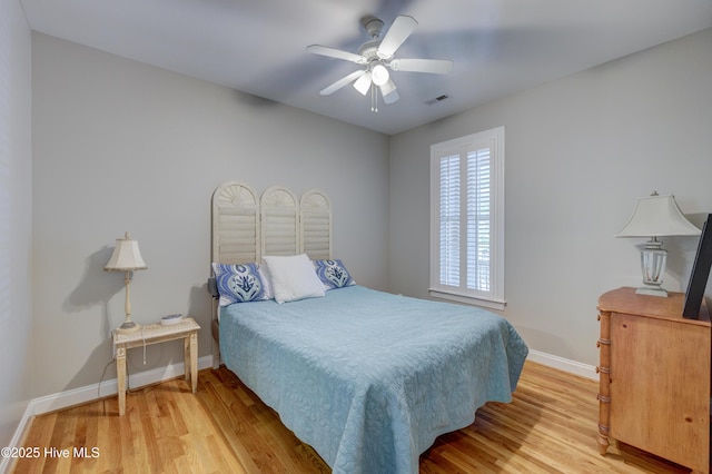 bedroom with baseboards, visible vents, ceiling fan, and light wood-style floors