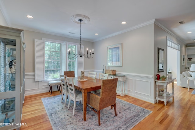 dining room with an inviting chandelier, visible vents, wainscoting, and light wood-style floors