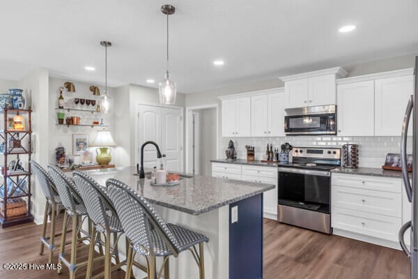 kitchen featuring dark stone counters, recessed lighting, appliances with stainless steel finishes, and decorative backsplash