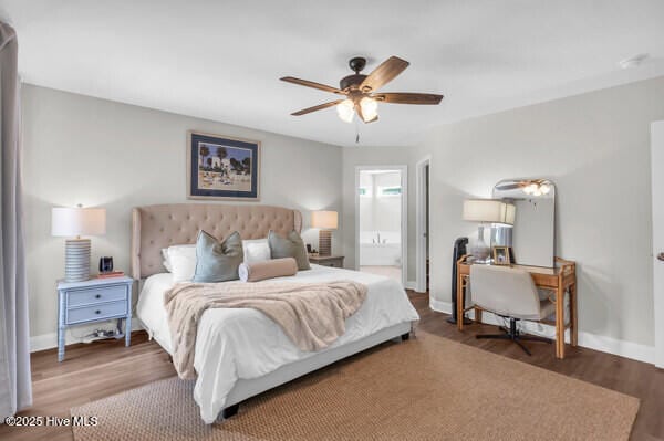 bedroom with wood finished floors, ensuite bathroom, and baseboards