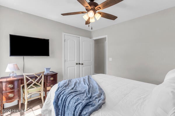 bedroom featuring wood finished floors, a ceiling fan, and a closet