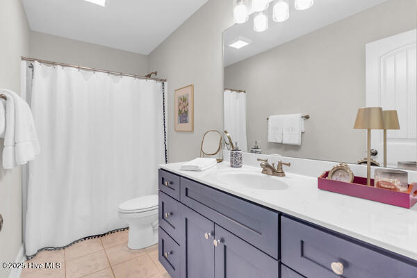bathroom with a shower with shower curtain, toilet, tile patterned flooring, and vanity