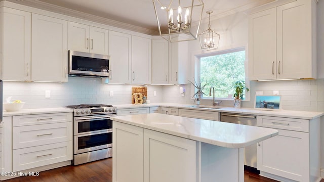 2417 Turtle Bay Dr, New Bern, NC 28562 - kitchen with decorative backsplash, white cabinets, a sink, a notable chandelier, and stainless steel appliances