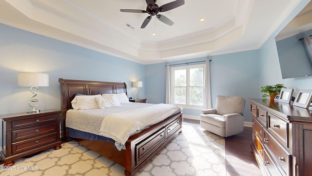 2417 Turtle Bay Dr, New Bern, NC 28562 - bedroom with a ceiling fan, visible vents, crown molding, a tray ceiling, and light wood-style flooring