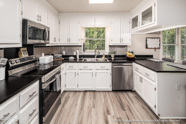 869 Driftwood Dr, Greenville, NC 27858 - kitchen featuring stainless steel appliances, a sink, dark countertops, a peninsula, and white cabinetry