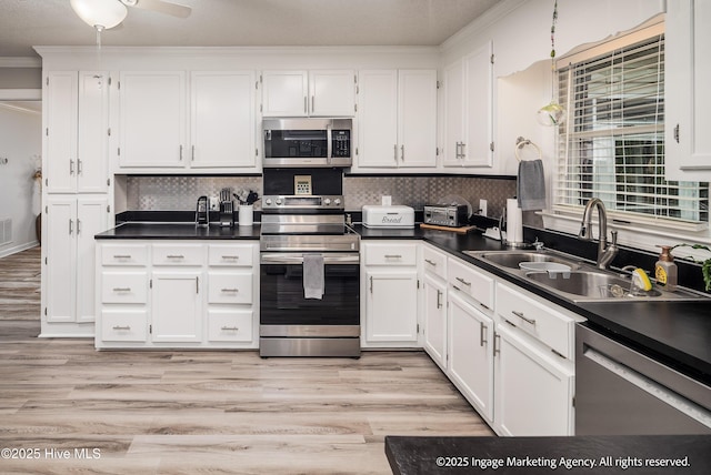 869 Driftwood Dr, Greenville, NC 27858 - kitchen featuring stainless steel appliances, ornamental molding, white cabinetry, a sink, and dark countertops