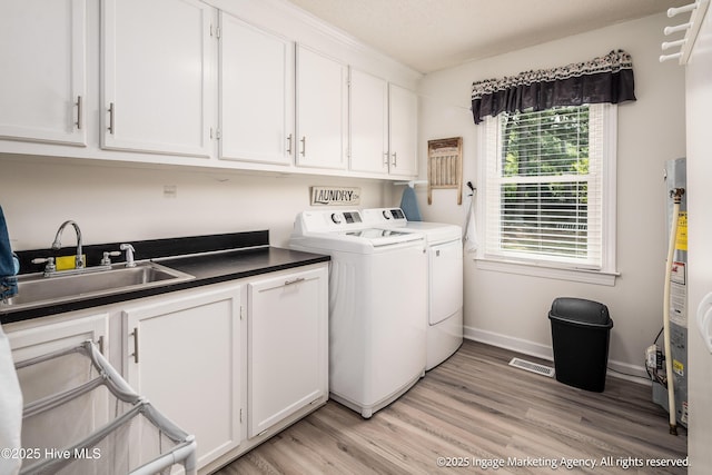 869 Driftwood Dr, Greenville, NC 27858 - laundry area featuring washing machine and clothes dryer, cabinet space, light wood finished floors, and baseboards