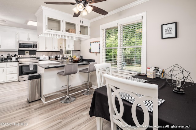 869 Driftwood Dr, Greenville, NC 27858 - kitchen featuring stainless steel appliances, dark countertops, ornamental molding, a ceiling fan, and white cabinets