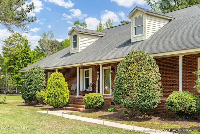 869 Driftwood Dr, Greenville, NC 27858 - cape cod home with a porch, brick siding, a front lawn, and roof with shingles