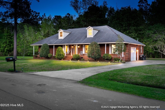 869 Driftwood Dr, Greenville, NC 27858 - new england style home featuring a porch, driveway, a front yard, brick siding, and an attached garage