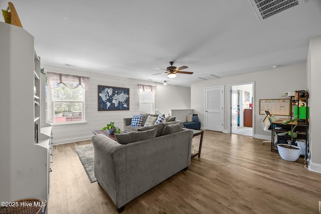 living room with a healthy amount of sunlight, a ceiling fan, visible vents, and wood finished floors