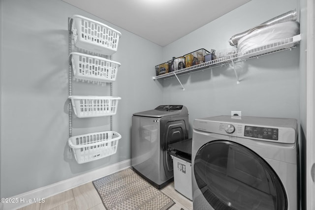laundry room featuring baseboards, laundry area, and independent washer and dryer