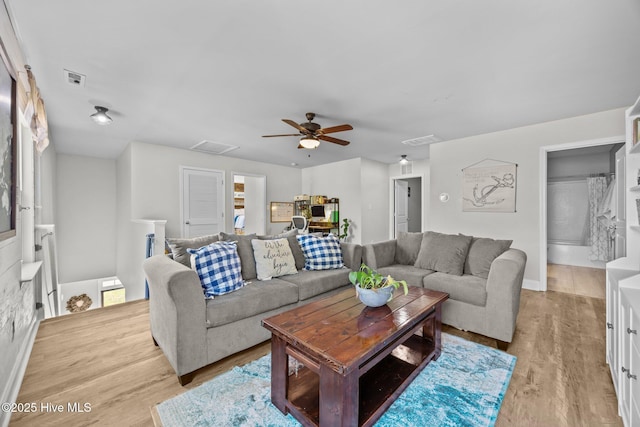 living area with light wood finished floors, visible vents, and ceiling fan