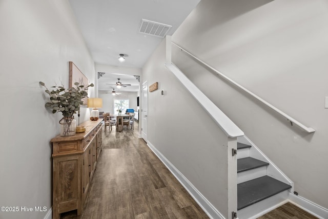 corridor featuring visible vents, dark wood-style flooring, baseboards, and stairs