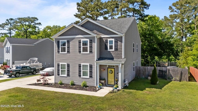 view of front of home featuring driveway, roof with shingles, fence, and a front yard
