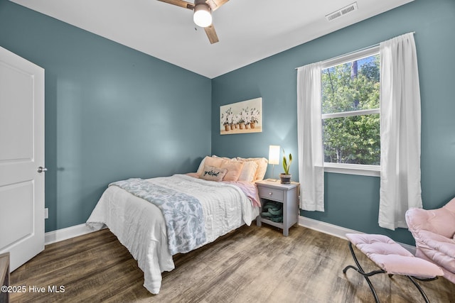 bedroom with ceiling fan, baseboards, visible vents, and wood finished floors